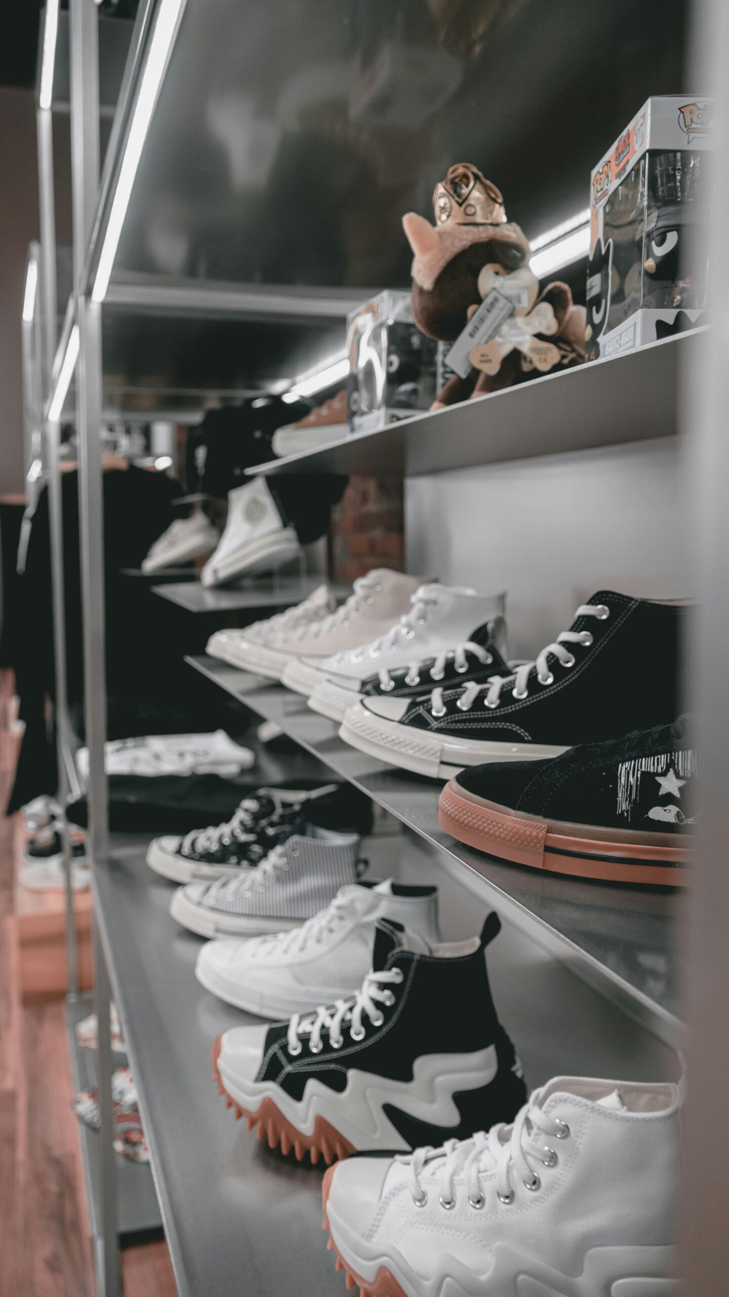 Stylish high-top sneakers arranged on metal shelves in a contemporary sneaker shop
